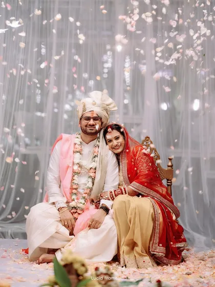 A serene portrait of the couple amidst a rain of flowers, capturing a moment of peace during the vibrant ceremony.