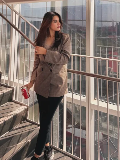 A confident pose on a staircase, this shot is part of my "on-the-go college outfit" series. The modern, sunlit architecture provides a great backdrop for this smart-casual look.