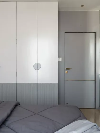 This minimalist wardrobe is designed to blend functionality with elegance, featuring a sleek dual-tone finish and circular handles for a playful yet sophisticated touch. The seamless design optimizes space while maintaining a clean, contemporary aesthetic.