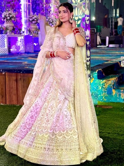 The full look of the ivory lehenga, showcasing its beautiful flare and intricate work. We are dedicated to providing quality and speed.