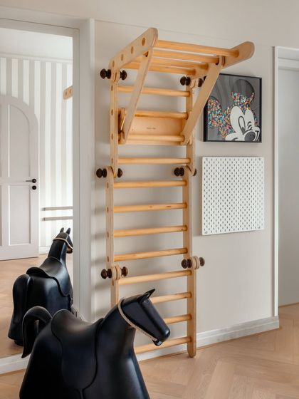We believe homes should be for living, not just for show. This corner of the children's play area, with its wooden climbing frame and rocking horse, is a testament to creating spaces that are a little imperfect and a lot of fun.