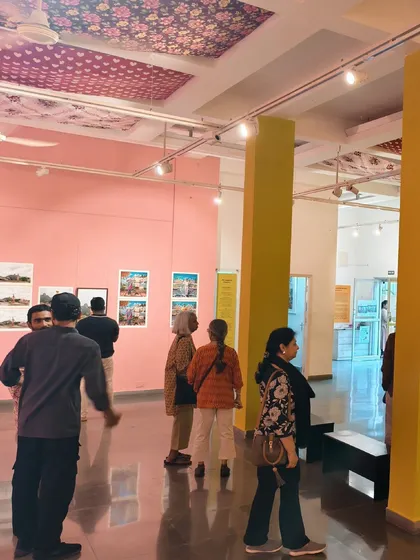 Visitors exploring the colorful gallery space during the final days of 'No Longer A Memory'. The bright pink and yellow walls were an integral part of the immersive experience.