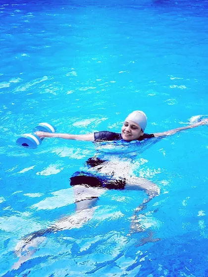 This demonstrates a floating back-stroke exercise with dumbbells. It's a challenging yet effective movement for engaging the core and back muscles while floating.