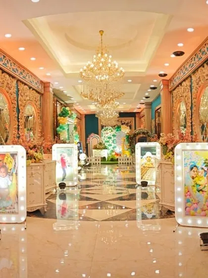 The grand and opulent hallway of a wedding venue, decorated with ornate mirrors and floral arrangements.
