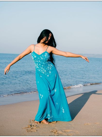A joyful, carefree moment captured on the beach. The movement in the dress and hair conveys a sense of freedom and happiness.