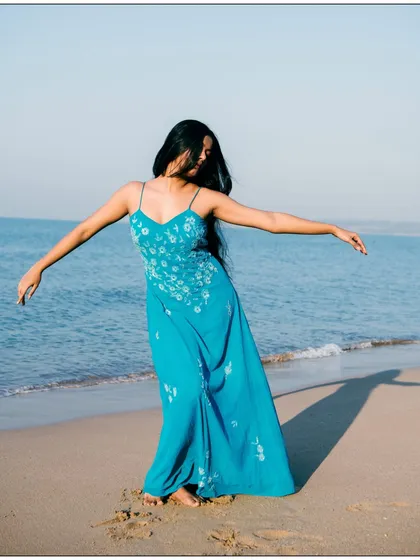 A joyful, carefree moment captured on the beach. The movement in the dress and hair conveys a sense of freedom and happiness.