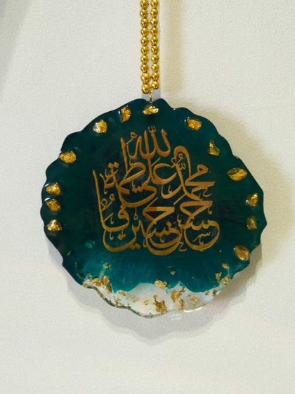 A clear, studio-style shot of the Panjatan name car hanging. This view highlights the intricate gold calligraphy against the deep teal resin.