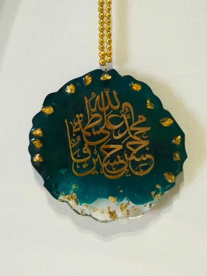 The Panjatan car hanging against a white background, showing the beautiful gold chain and details.