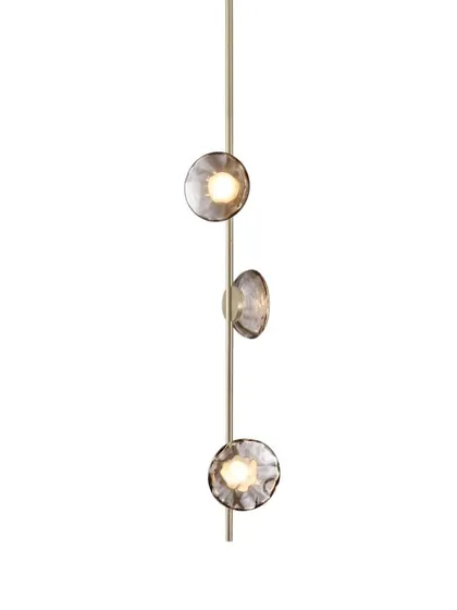 A studio shot of a vertical Ceto lamp with a champagne aluminum body, offering a softer and warmer alternative to the black finish.