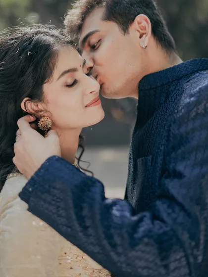 A tender moment from a pre-wedding shoot. Her makeup is soft and romantic, with closed eyes showing off the subtle eyeshadow work, creating a dreamy and intimate feel.