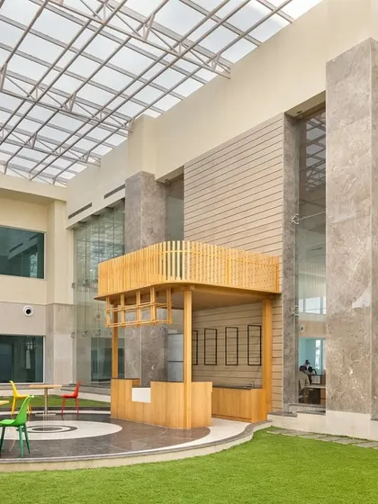 At Pragma Medical Institute, a sunlit central atrium with a glass roof creates a vibrant, year-round garden. This biophilic centerpiece serves as a natural orientation point and a calming destination for patients and visitors.