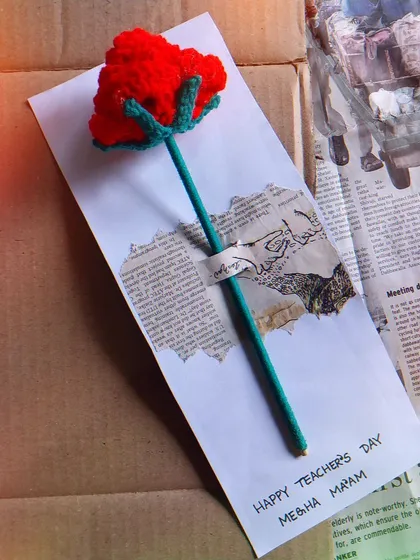 A close-up of a Teacher's Day rose card with personalized name.