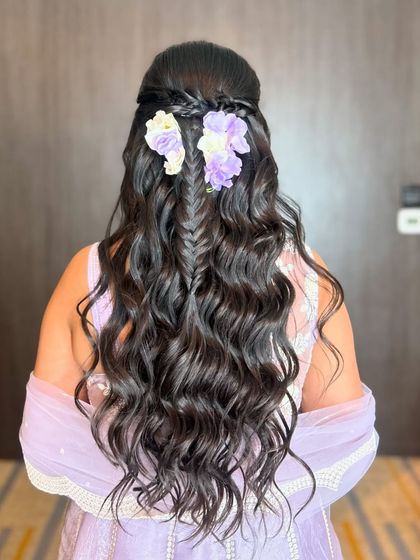 A clearer view of the fishtail braid and floral hairstyle, showing the beautiful contrast of the purple flowers against the dark hair.