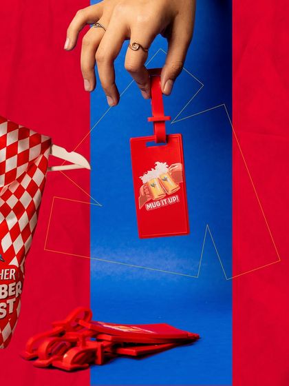 We designed custom merchandise like these "Mug It Up!" luggage tags for the Kingfisher Oktoberfest activation. This tangible takeaway helped create a strong brand presence and lasting memory for participants.