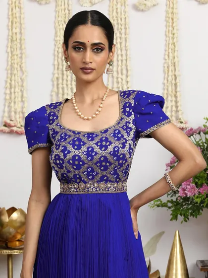 A stunning royal blue gown with an embellished Bandhani blouse featuring statement puff sleeves. This is a true fusion of traditional craft and modern design.