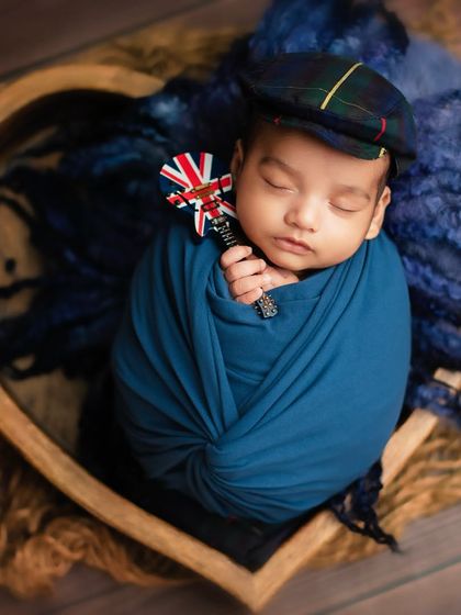 A little gentleman with a nod to Britain. Themed props like this Union Jack rattle can add a personal touch to a classic studio portrait.