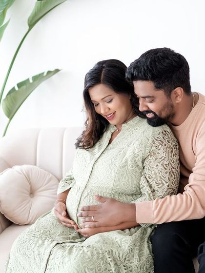 A tender moment during a couple's maternity session. The focus is on their shared joy and anticipation.