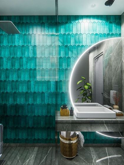 This bathroom concept uses a striking turquoise tile for the shower wall, creating a bold splash of color against the grey marble. The round, backlit mirror adds a modern, graphic element.
