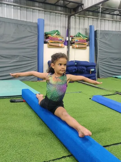 Every champion was once a beginner. Here, a young gymnast shows amazing flexibility and balance, practicing her splits on our professional-grade padded beam. We help kids safely push their limits and discover what their bodies can do.