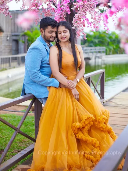 An intimate portrait under the pink blossoms. The soft focus and vibrant colors create a dreamy and romantic pre-wedding photograph.