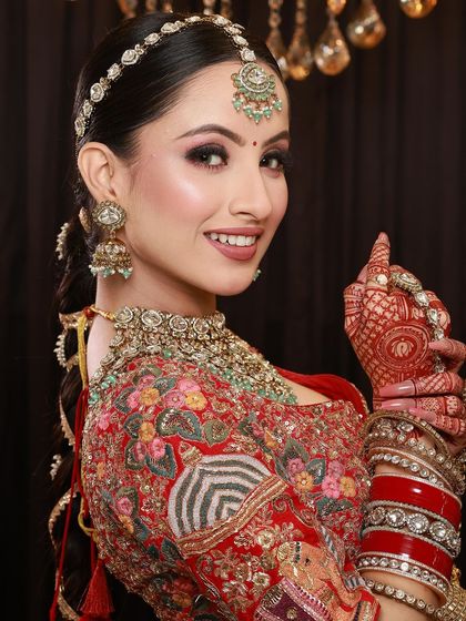 A happy bride pointing with her mehandi-adorned finger, her smile and the art on her hands radiating joy.