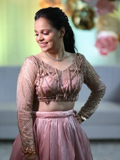 A happy, smiling Komal. The soft pink eyeshadow and glowing skin create a look that is fresh and youthful.