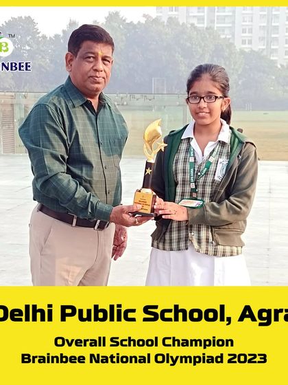 A student from DPS Agra receives her trophy for an outstanding performance in the 2023 Olympiad.