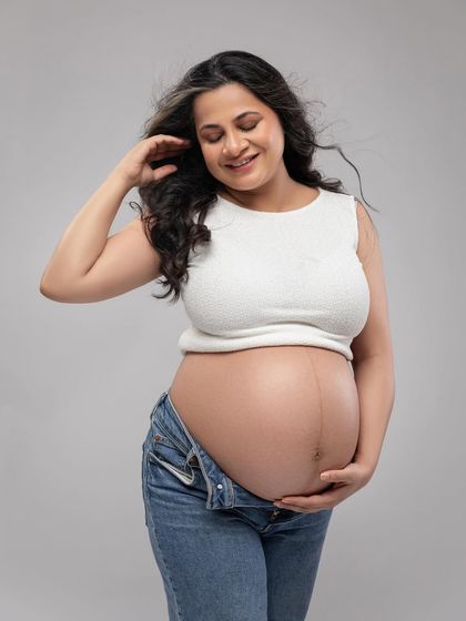 A close-up on the bump. This tender shot with the wind in her hair feels natural and full of love.