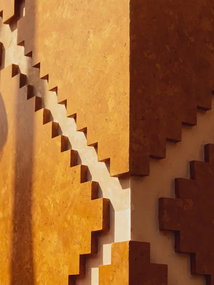 This is a close-up of the modular facade at Stone Print Villa. What appears as a simple stepped pattern from afar is a system of precisely calibrated CNC-cut panels made from a stone-resin composite. It's a way we use technology to articulate form and create rhythmic, textured surfaces.