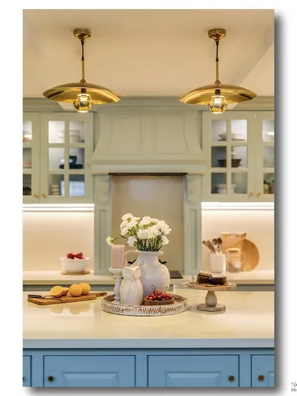 A close-up of the kitchen island, styled with fresh flowers, fruit, and a cake stand. This shot highlights the kitchen as a space for gathering and enjoyment, focusing on the warm and inviting details.