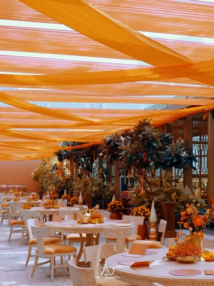 I believe in the power of color to transform a space. For this traditional Mamera event, I used flowing orange drapes and lush greenery to create a warm, vibrant, and joyful setting for the daytime celebration.