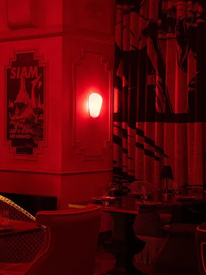 A corner detail showing a vintage-style "Siam" poster, adding a layer of nostalgic charm to the contemporary design.