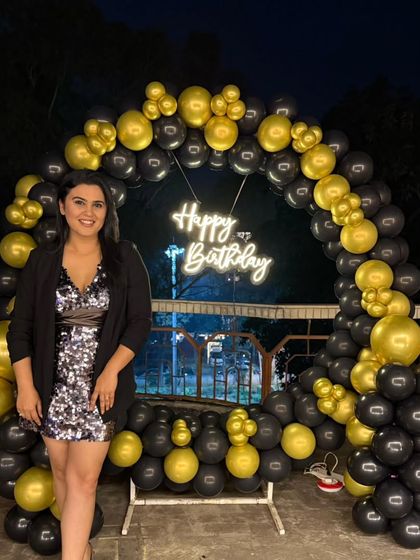 The birthday girl posing against the beautiful night-time backdrop of her terrace party decoration.