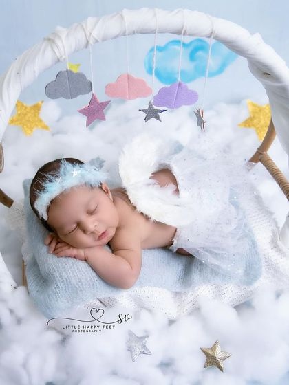 Another beautiful angel portrait, this time with a mobile of stars and clouds. The soft lighting and ethereal props create a feeling of peace and wonder.