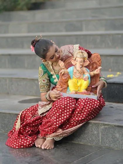 A candid moment of admiration for the Ganpati idol, dressed in full festive attire.
