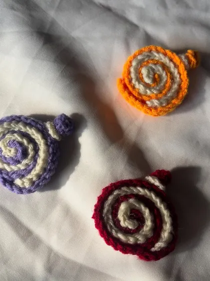 My collection of handmade cake roll charms, ready to be sent out. Each one is crocheted by hand by me.