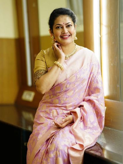 This shot highlights the rich texture of the Banarasi silk saree and the detailed embroidery on the blouse sleeve.
