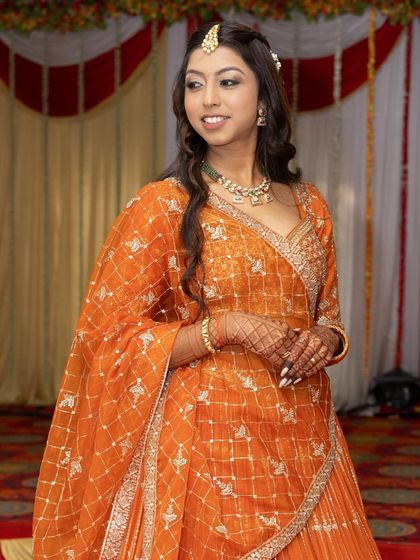 A close-up of the orange lehenga highlights the detailed embroidery on the blouse and the delicate fabric of the dupatta. It’s a testament to the quality and craftsmanship you can expect from my rental collection.