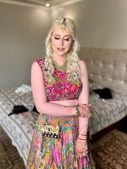 A half-updo with soft curls for a colorful Mehndi look, perfect for a fun and vibrant celebration.