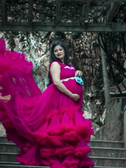 A powerful and dramatic outdoor portrait on a set of stone stairs. The movement of the flowing magenta gown creates a stunning visual against the architectural backdrop.