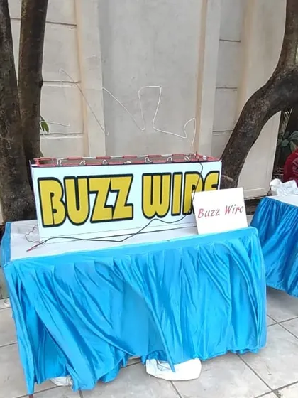 The buzz wire game tests focus and a steady hand. Players must guide a metal loop along a winding wire without touching it and setting off the buzzer.