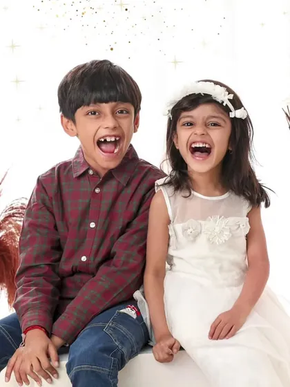 The bond between siblings is a precious thing. This image captures a moment of shared, explosive laughter between a brother and sister during their photoshoot. These are the authentic, happy memories that make for the most cherished sibling portraits.
