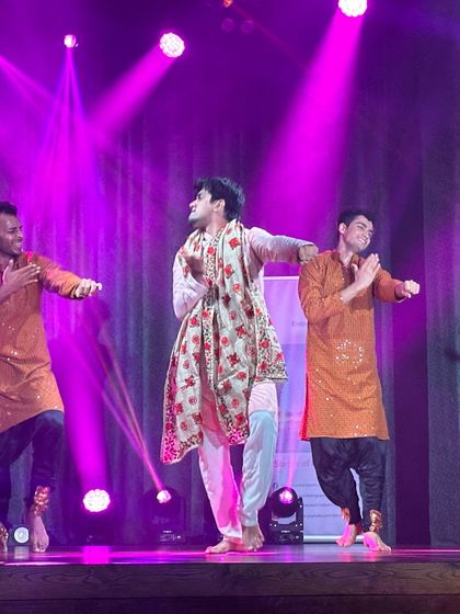 Another look at a celebratory group dance, showcasing coordinated outfits and joyful expressions. We focus on formations and stage presence to make your family's sangeet performance look polished and professional.