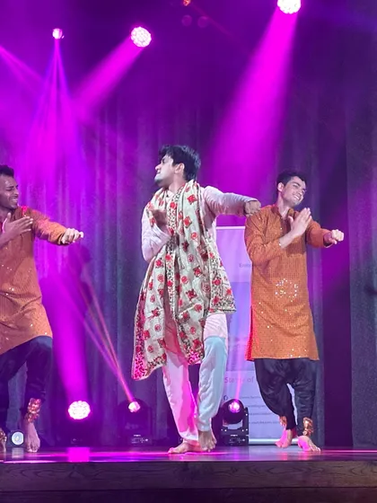 Another look at a celebratory group dance, showcasing coordinated outfits and joyful expressions. We focus on formations and stage presence to make your family's sangeet performance look polished and professional.