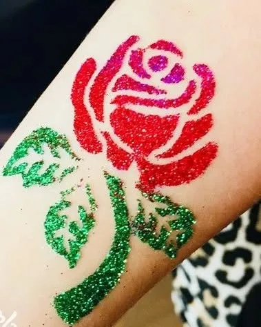 A classic rose tattoo in sparkling red and green glitter. This timeless design is always a beautiful choice.