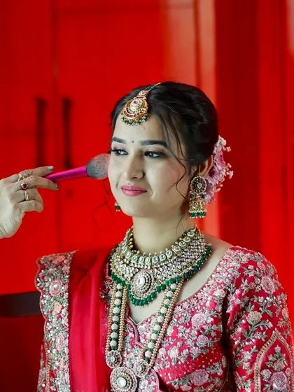 A moment of final touches. This shot captures the beautiful details of her makeup and stunning polki and emerald jewelry.