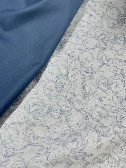 This beautiful fabric features a swirling, floral-like print in blue on a white background. It can be paired with a matching blue izaar for a complete outfit.