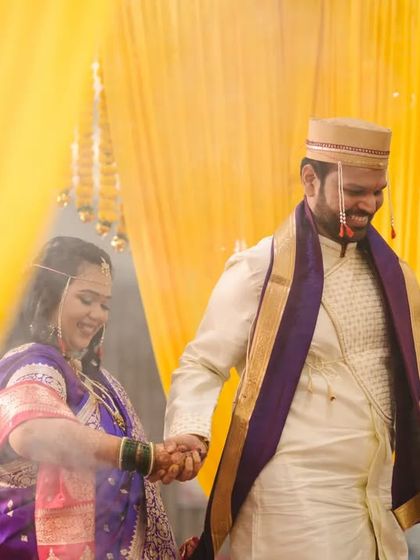 The couple holding hands as they walk through a cloud of holy smoke, a beautiful and symbolic moment from their wedding ceremony.