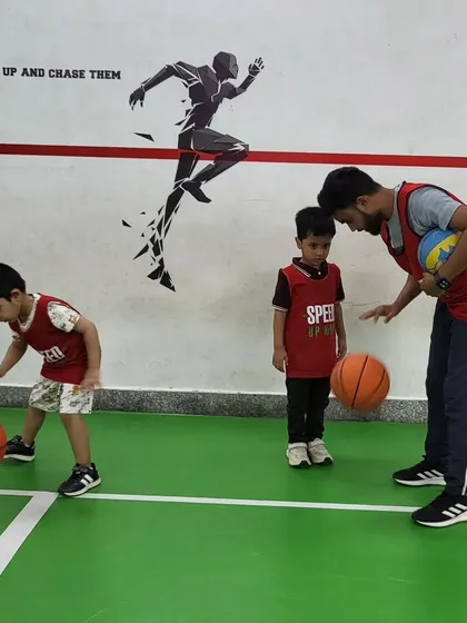 A coach provides one-on-one instruction on dribbling. This personalized attention helps kids grasp the technique correctly and build confidence.