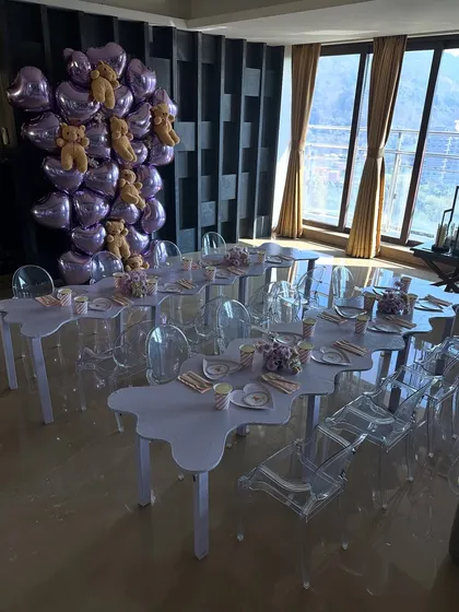 An overview of the kids' dining setup for Leila's teddy bear house party, featuring cloud-shaped tables and clear ghost chairs for a modern, airy feel.